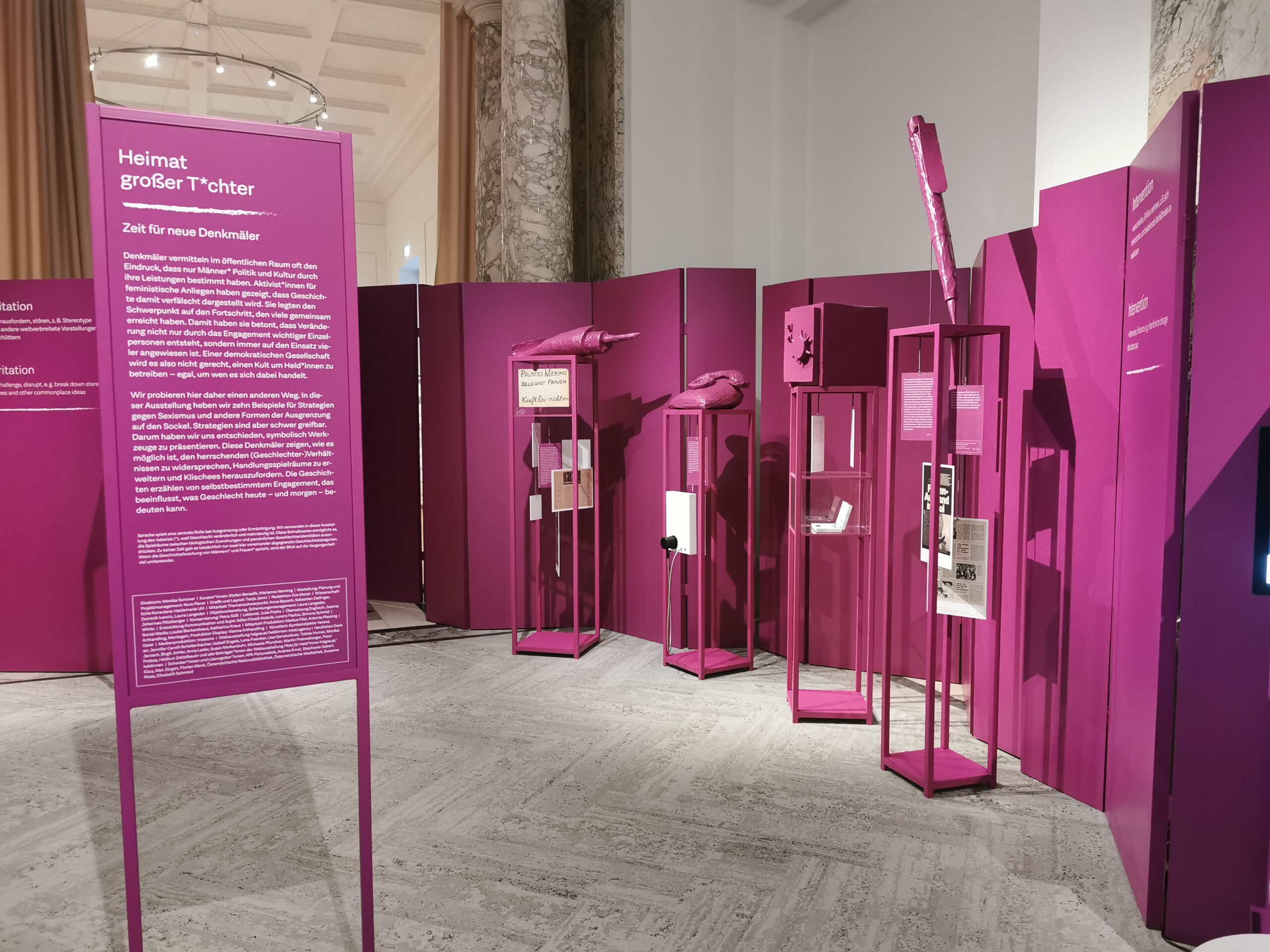 Eine Ausstellung "Heimat grösser T*chter", alles dunkel Pink und vier Vitrine zu sehen.