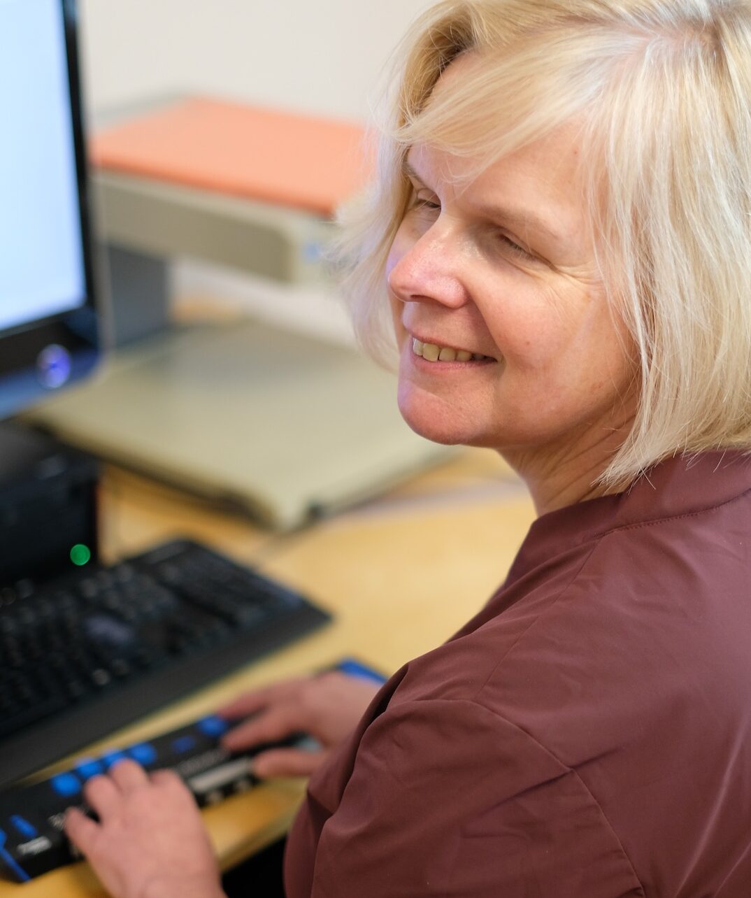 Susanne Buchner-Sabathy arbeitet an ihrem PC mit einer Braille-Zeile